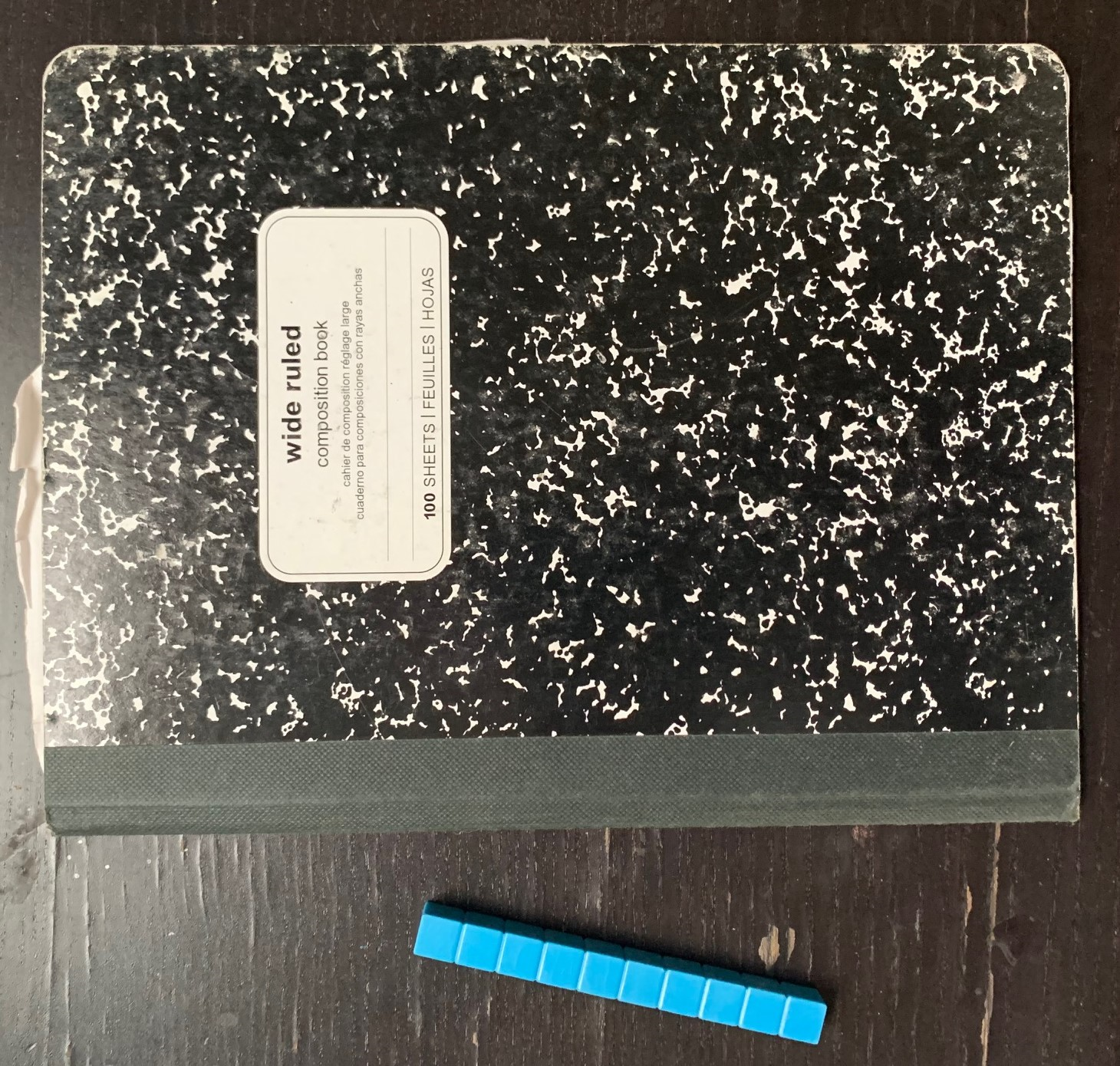 Notebook lying next to a 10-centimeter tool.