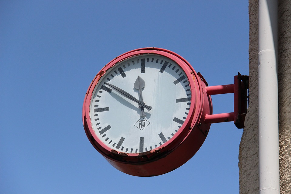 photo of a clock attached to the side of a building