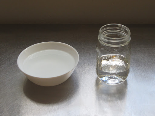 A bowl and jar, both partially filled with water.
