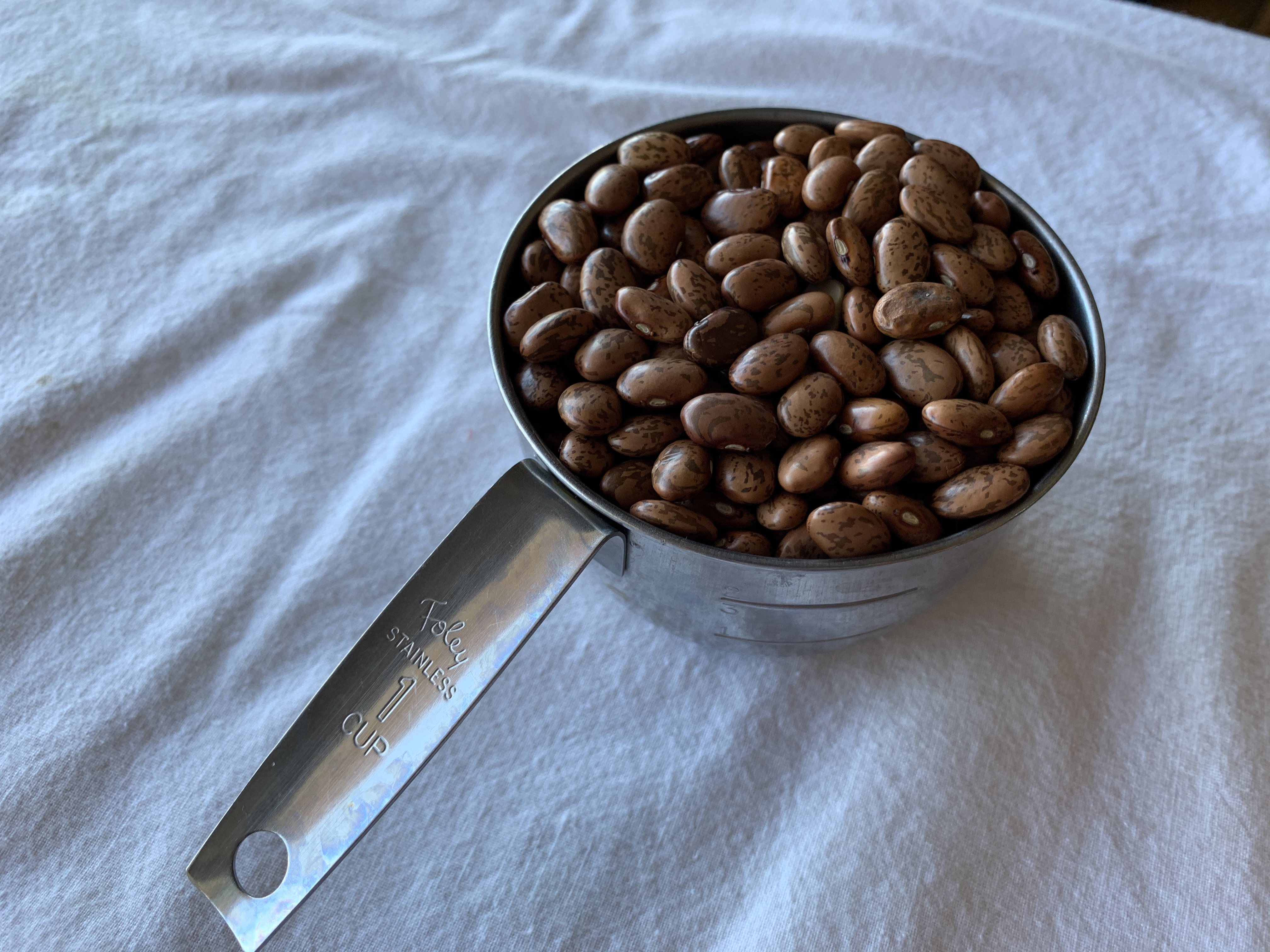 1 cup measuring cup filled with beans.