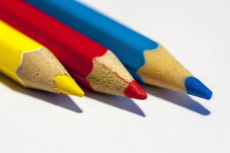 three colored pencils, yellow, red, blue
