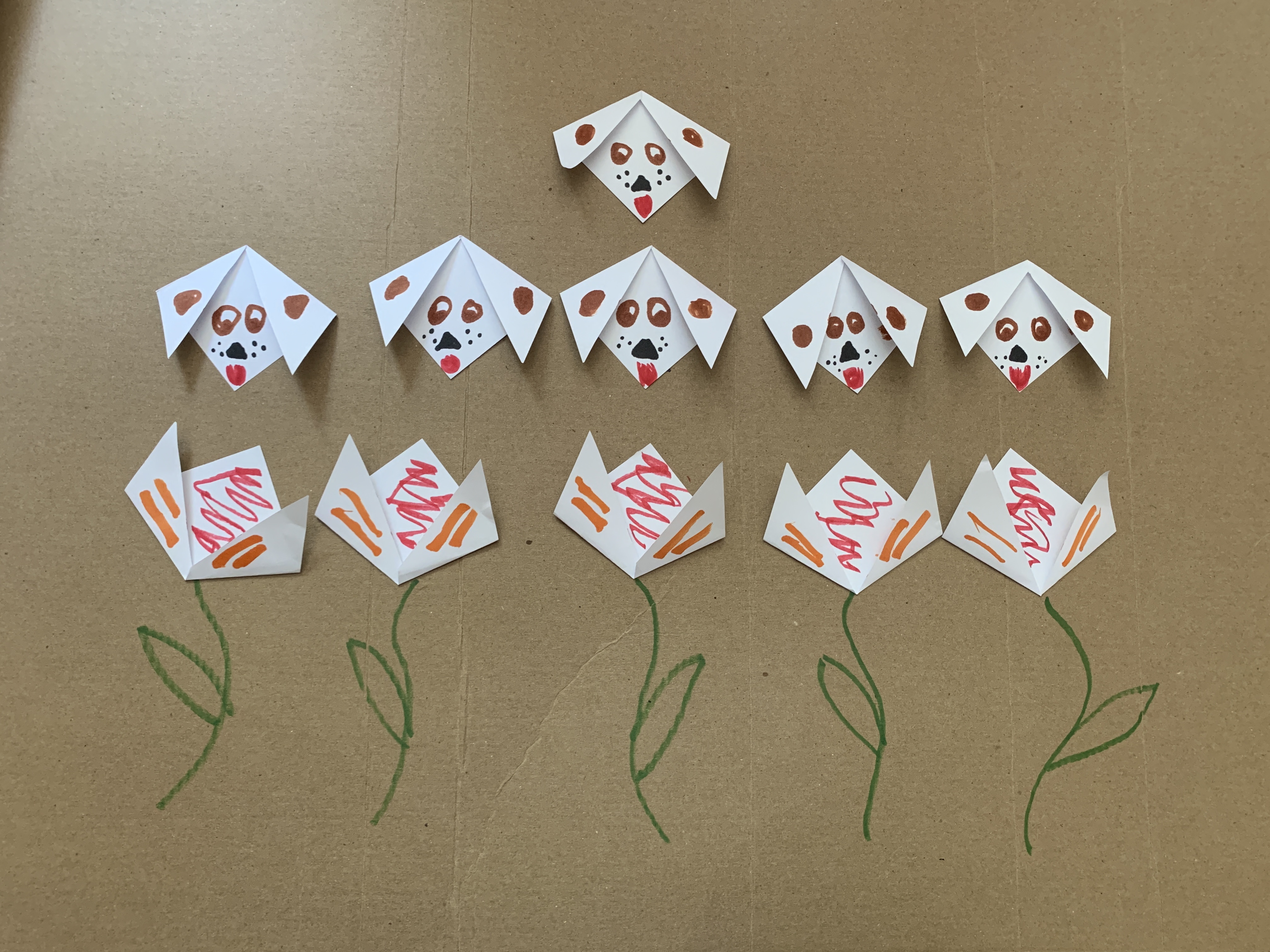 Small pieces of paper folded and decorated as puppies or tulips.