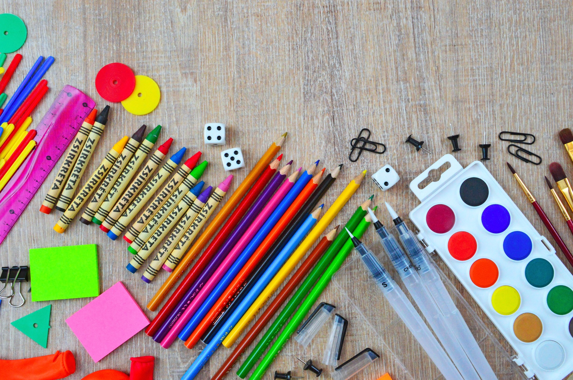 School supplies. pencils, crayons, paint, paint brushes, number cubes, sticky notes, paperclips.