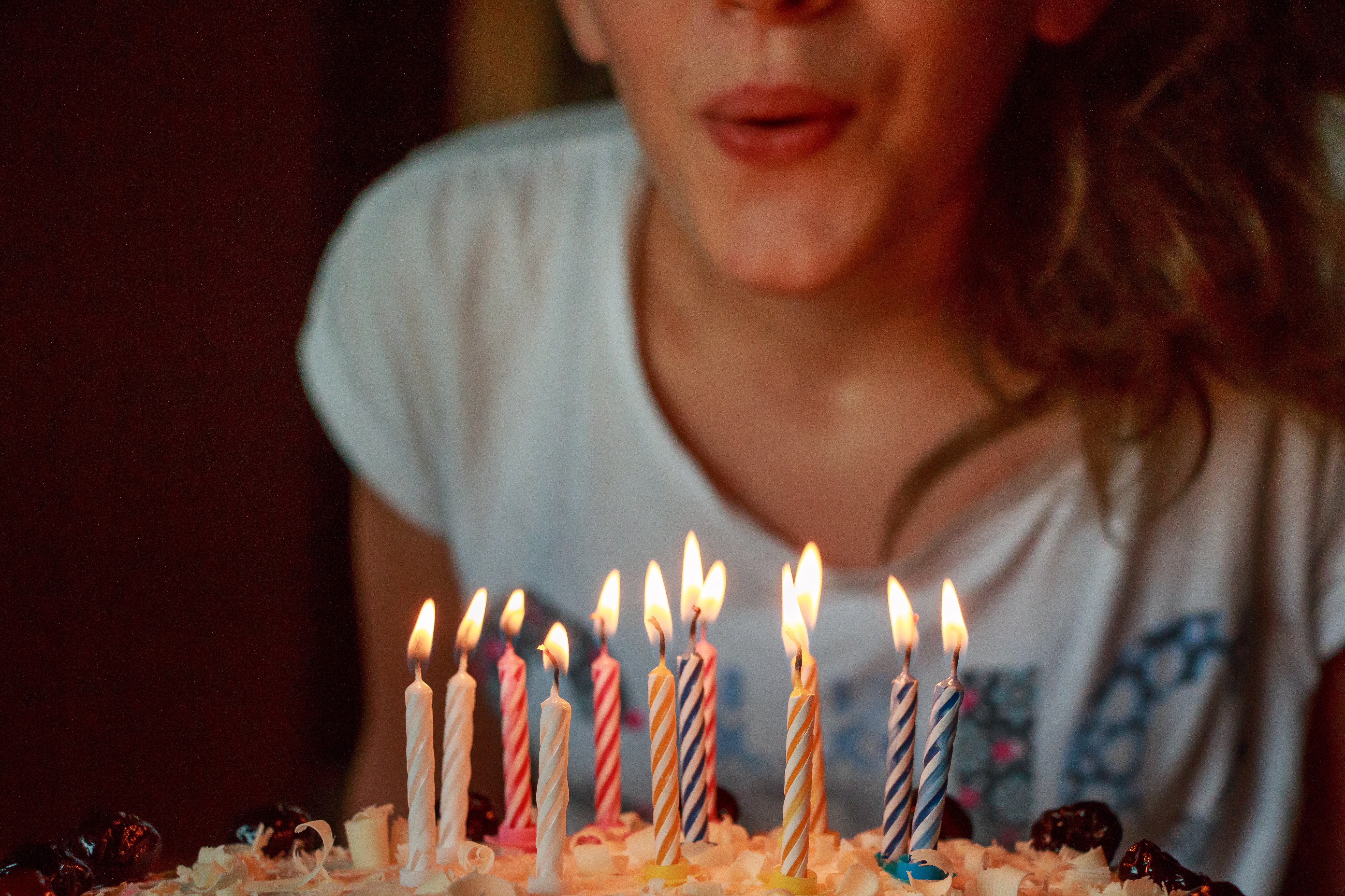 Girl blowing out candles on a cake. 