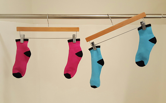 An image of a pair of red socks and a pair of blue socks on hangers