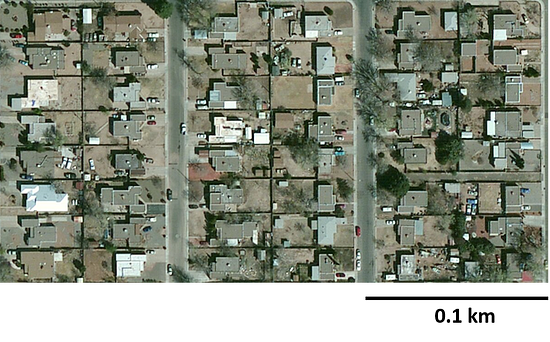 An aerial image of a neighborhood displaying the roofs of houses. Each 0 point1 kilometer by 0 point 1 kilometer area has a total of 8 houses.
